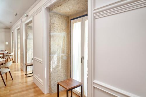 a room with a door and a table and chairs at The Vinea Collection Hotel by Piamonte Hotels in Monção