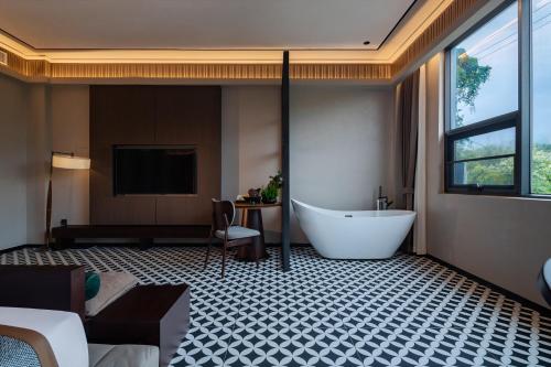 a large bathroom with a tub and a tv at 诺亚度假酒店 in Luang Prabang