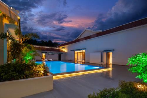 a villa with a swimming pool at night at 诺亚度假酒店 in Luang Prabang
