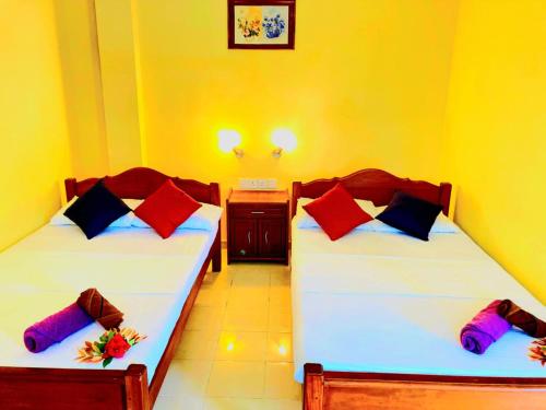 two twin beds in a room with at Ayurweda spa Hotel in Deniyaya