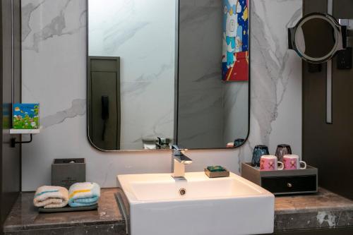 a bathroom with a white sink and a large mirror at Crowne Plaza Wuhan Development Zone by IHG in Wuhan
