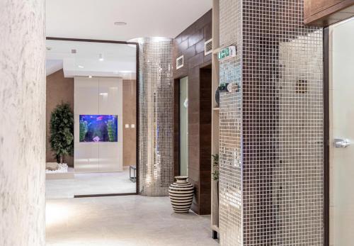 a bathroom with a wall of tile at Spa Hotel Persenk in Devin