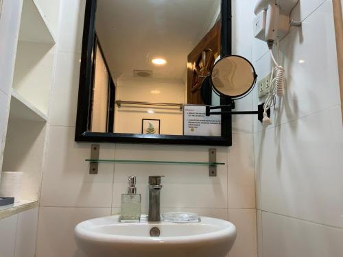 a bathroom with a sink and a mirror at TLT Condotl E-208 -Near Airport at Kiener Hills Condominium in Mactan