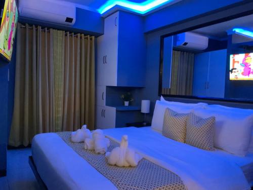 a bedroom with a large bed with blue lighting at TLT Condotl E-208 -Near Airport at Kiener Hills Condominium in Mactan