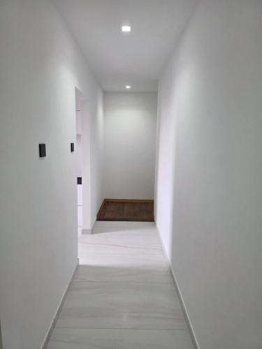 an empty hallway with white walls and a wooden floor at Apartamenty KORONA in Krosno