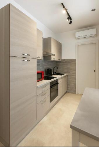 a kitchen with stainless steel cabinets and a red appliance at SerMar in Porto Torres