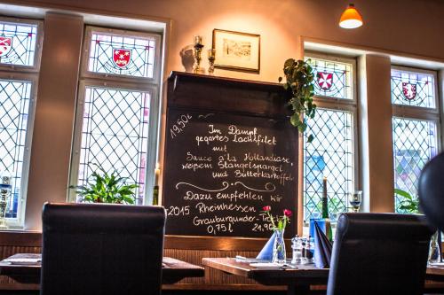a menu on a chalkboard in a restaurant with windows at Hotel Blaue Ecke in Adenau