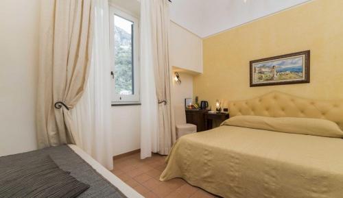a bedroom with a bed and a window at Hotel Villa Annalara charme and Relax in Amalfi