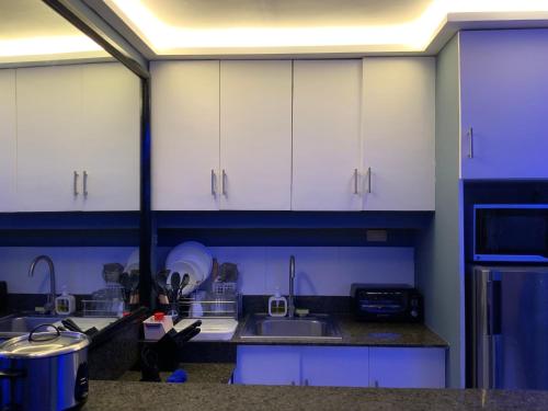 a kitchen with white cabinets and a sink at TLT Condotl E-208 -Near Airport at Kiener Hills Condominium in Mactan