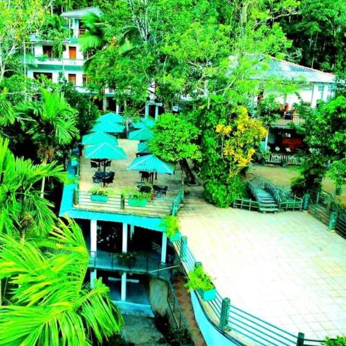 a resort with tables and umbrellas on a bridge at Ayurweda spa Hotel in Deniyaya