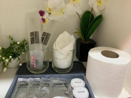 a shelf with a roll of toilet paper and flowers at TLT Condotl E-208 -Near Airport at Kiener Hills Condominium in Mactan
