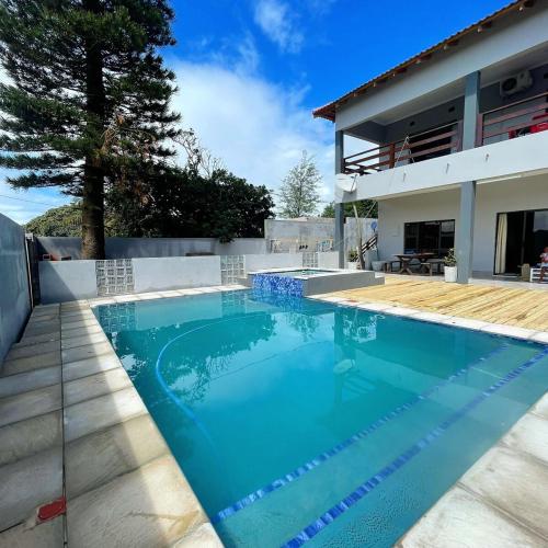 a swimming pool in front of a house at Lar do Índico in Fombeni