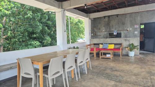 a dining room with a wooden table and chairs at Camotes Hostel Resort in Camotes Islands