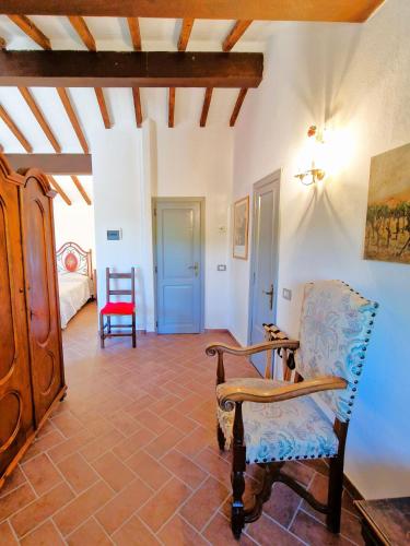 a living room with a chair and a bedroom at Borgo Melograno in Chiusi