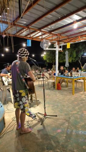 a man standing in a room with a guitar at Camotes Hostel Resort in Camotes Islands