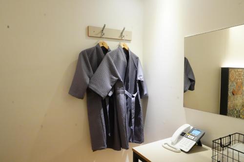 a row of jackets hanging on a wall next to a mirror at First Hotel Geoje in Geoje 