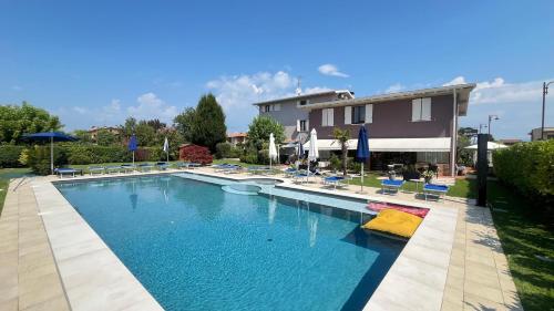 a large swimming pool with chairs and umbrellas at Hotel Bolero in Sirmione