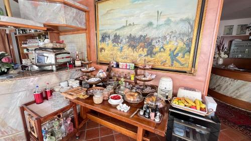 a kitchen with a table with food and a painting at Hotel Bolero in Sirmione