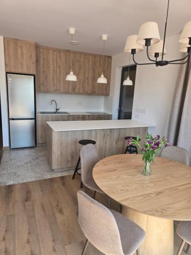 a kitchen with a wooden table and chairs and a counter at Eko Osada Zacisze in Ostrowite
