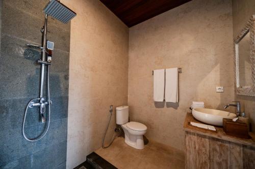 a bathroom with a shower and a toilet and a sink at Oka Suite Sebatu Ubud in Tampaksiring