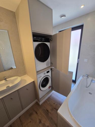 a bathroom with a washing machine and a sink at Eko Osada Zacisze in Ostrowite
