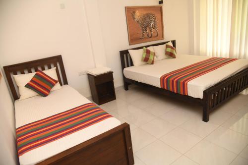 a bedroom with two beds at Traget safari home stay in Udawalawe