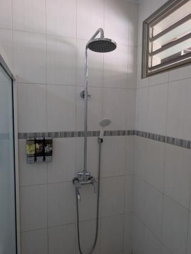 a shower with a shower head in a bathroom at Iolana's Beach house - Beautiful Home in Punaauia