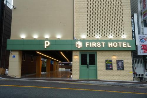 a hotel with a first hotel sign on a street at First Hotel Geoje in Geoje 
