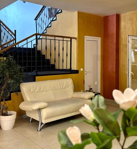 a living room with a white couch and stairs at Hotel Trio Giroc in Giroc