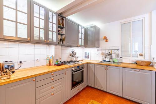 une cuisine avec des armoires blanches et des comptoirs en bois dans l'établissement GuestReady - Family Retreat in Bastille, à Paris