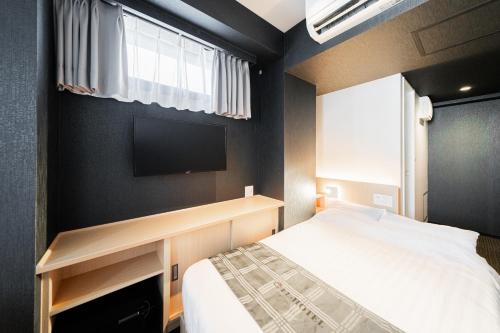 a bedroom with a bed and a flat screen tv at FL Hotel Asakusa in Tokyo