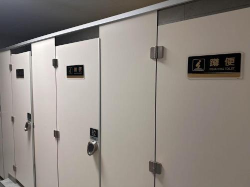 a row of lockers in a building with signs on them at Happy Bear Youth Hostel in Beijing