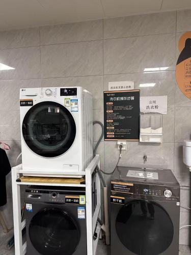 a microwave and a washing machine in a room at Happy Bear Youth Hostel in Beijing