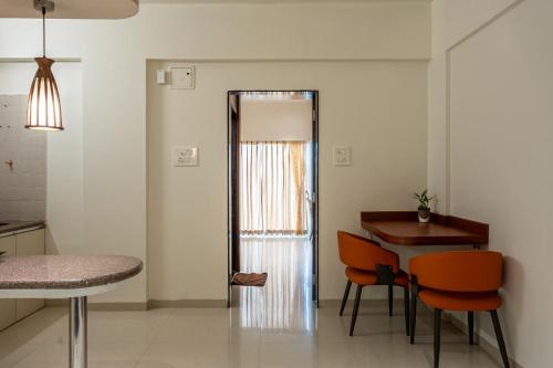 a kitchen with a table and chairs and a door at StayBird - Azure Suites, Business Hotel in Pune