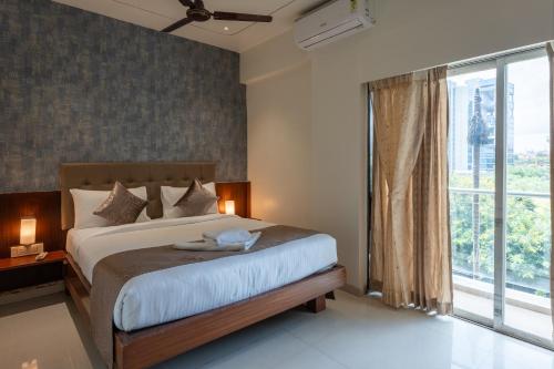 a bedroom with a bed and a large window at StayBird - Azure Suites, Business Hotel in Pune