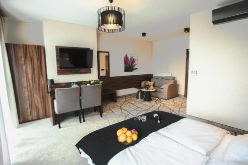 a hotel room with a bed and a living room at Hotel Pogoria Residence in Dąbrowa Górnicza