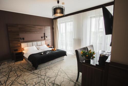 a bedroom with a bed and a large window at Hotel Pogoria Residence in Dąbrowa Górnicza
