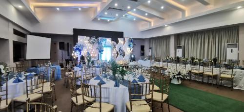 a banquet hall with white tables and chairs at Dancenter Boss Hotel Near Clark International Airport in Angeles