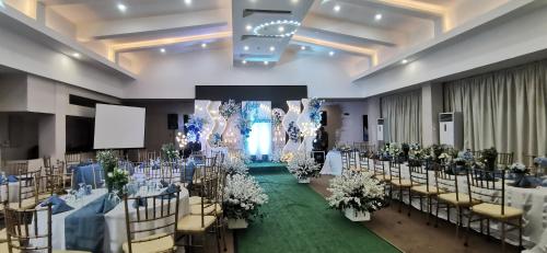 a banquet hall with tables and chairs in a room at Dancenter Boss Hotel Near Clark International Airport in Angeles