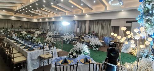 a banquet hall with white tables and chairs at Dancenter Boss Hotel Near Clark International Airport in Angeles