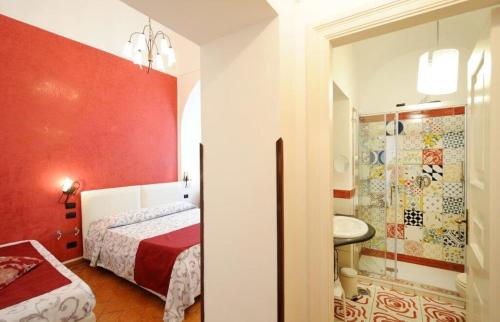 a bedroom with a bed and a bathroom with a sink at Hotel Villa Annalara charme and Relax in Amalfi