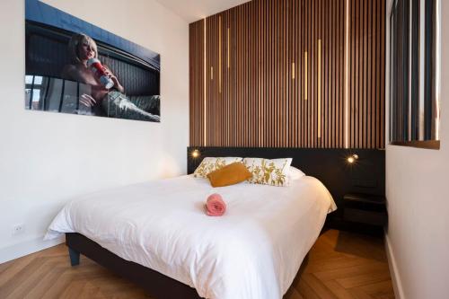 una camera da letto con un letto e una tv a parete di Les perchoirs de Stanislas 1 - logement de standing hyper centre a Nancy