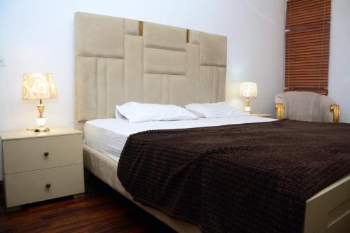 a bedroom with a large bed with a large headboard at 116 Apartments Luxestay CBD in Lahore