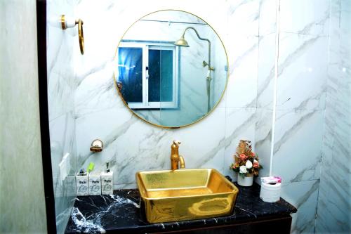 a bathroom with a gold sink and a mirror at 116 Apartments Luxestay CBD in Lahore