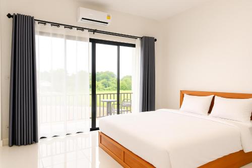 a bedroom with a bed and a large window at Sawaddee Pua Homestay(Cozy Home) in Pua