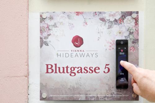 a person holding a remote control plugged into a lightswitch at Vienna Hideaways - Your Boutique Stay in Historic Old Town in Vienna