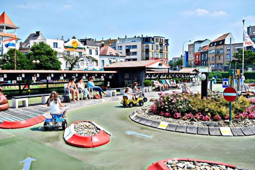 a group of people riding on toy cars in a playground at Chez’ Elle in Blankenberge