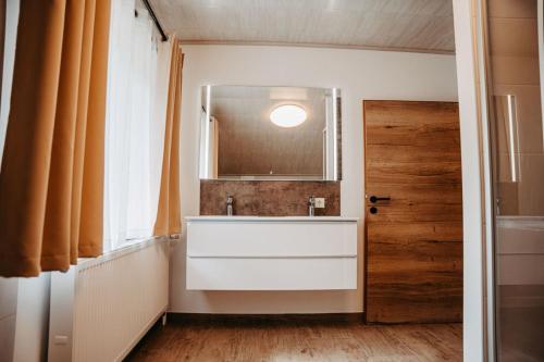 MittenにあるChalet Mittner Wirt Grosskirchheimの白い洗面台と鏡のあるバスルーム
