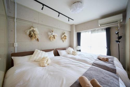 two beds in a bedroom with stuffed animals on the wall at Maison Etoile 706 / Vacation STAY 7561 in Nagoya