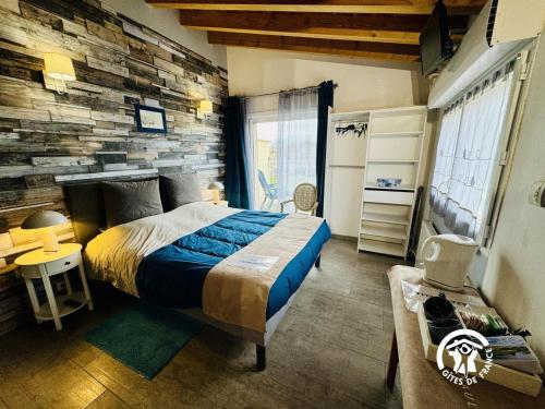 a bedroom with a bed and a stone wall at La cazabanelle in Villegly